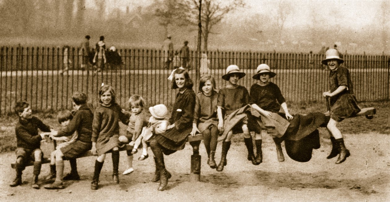 As crianças brincam em uma gangorra em um parque de Londres (foto sépia) de English Photographer