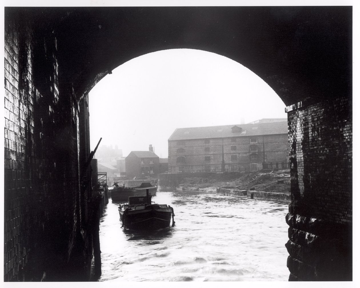 Rio Aire visto dos arcos escuros, Leeds, 1951 de English Photographer