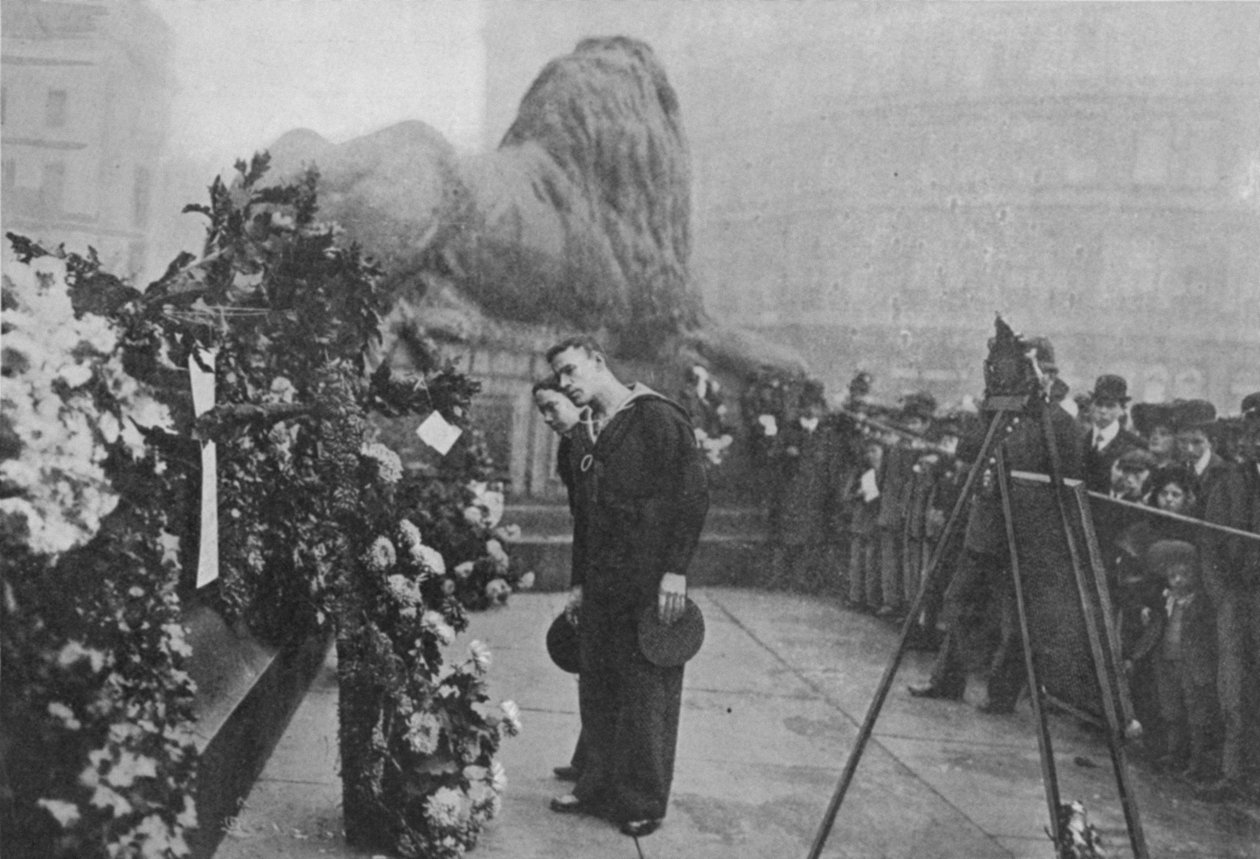 Sob Sombra Nelsons: Casacos-azuis inspecionando guirlandas no pé da estátua do almirante, publicado em The Graphic October 27th 1906 de English Photographer