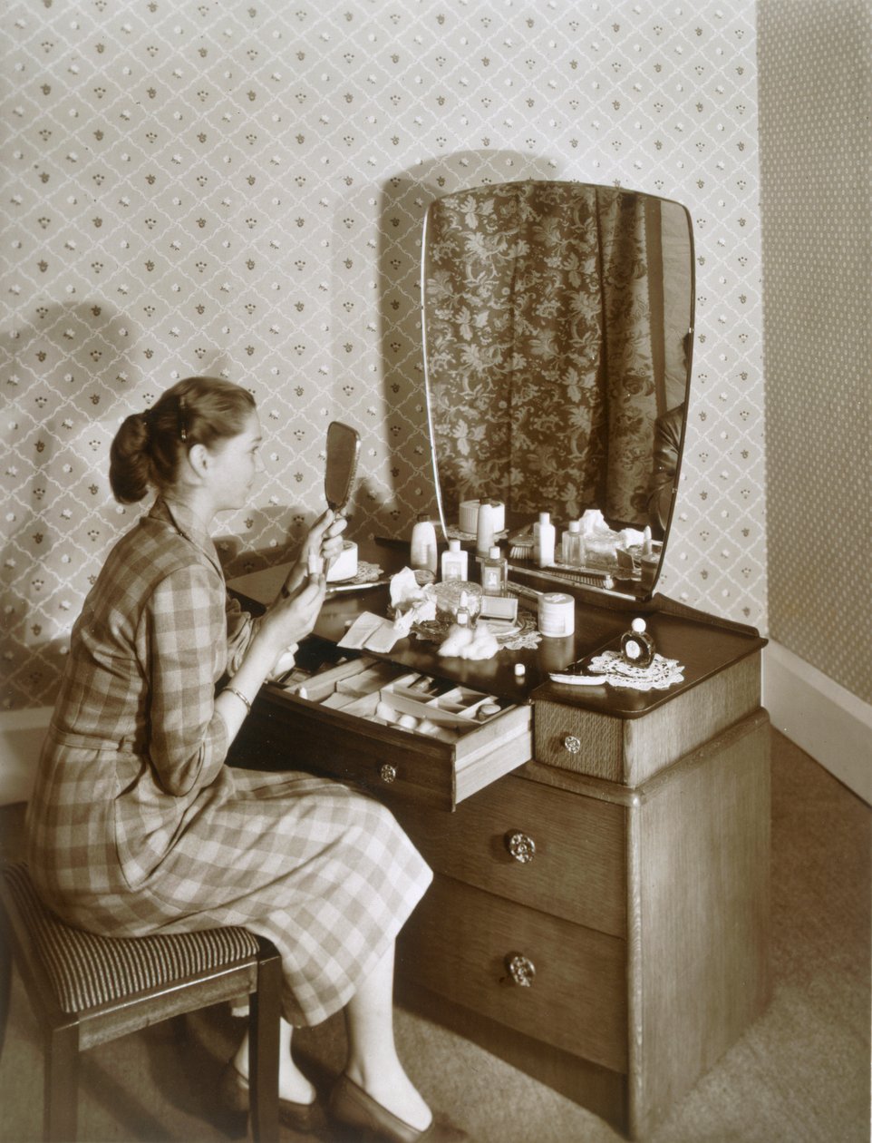 Mulher na penteadeira, c.1955 (foto sépia) de English Photographer