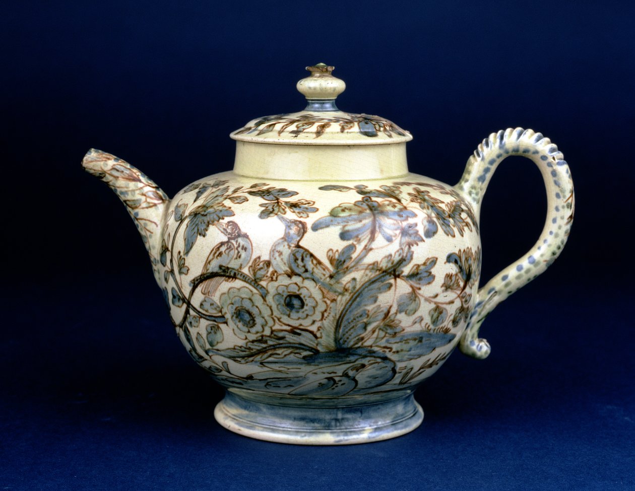 Bule Staffordshire Creamware conhecido como The Tunstall Teapot decorado com três pássaros em folhagem oriental, pintado em manganês acastanhado, o contorno aumentado em azul e verde por F. Morg de English School