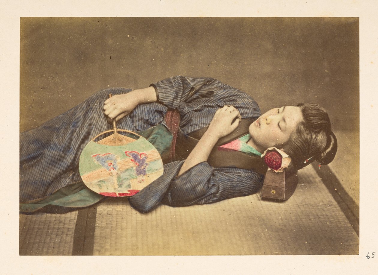 Japonesa dormindo, Retrato de estúdio de três quartos de uma jovem japonesa dormindo, segurando um ventilador na mão direita e com a cabeça apoiada em um travesseiro de madeira,   Fotógrafo: Desconhecido  Coleção Lucas: registro fotográfico do mundo t de English Photographer