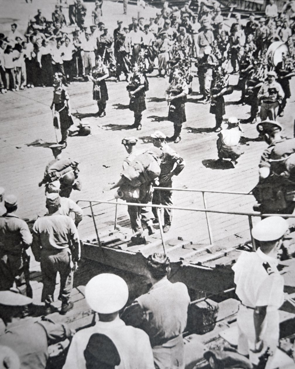 Os flautistas filtrados tocam em terra do 1º Batalhão Argyll e Sutherland Highlanders do HMS Ceilão em Pusan, 29 de Agosto de 1950 (foto a p/b) de English Photographer