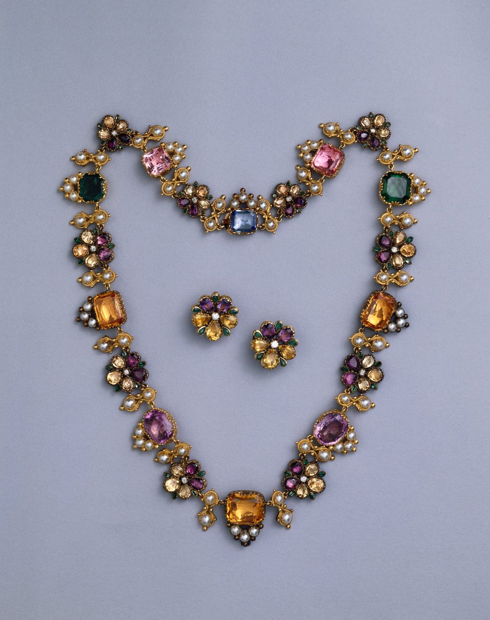 Um fino colar de ouro da Regência e joias com topázio recortado em almofada, ametistas, turmalinas rosa, esmeraldas, safiras e periodotas, com um par de brincos floridos, c.1810 de English School