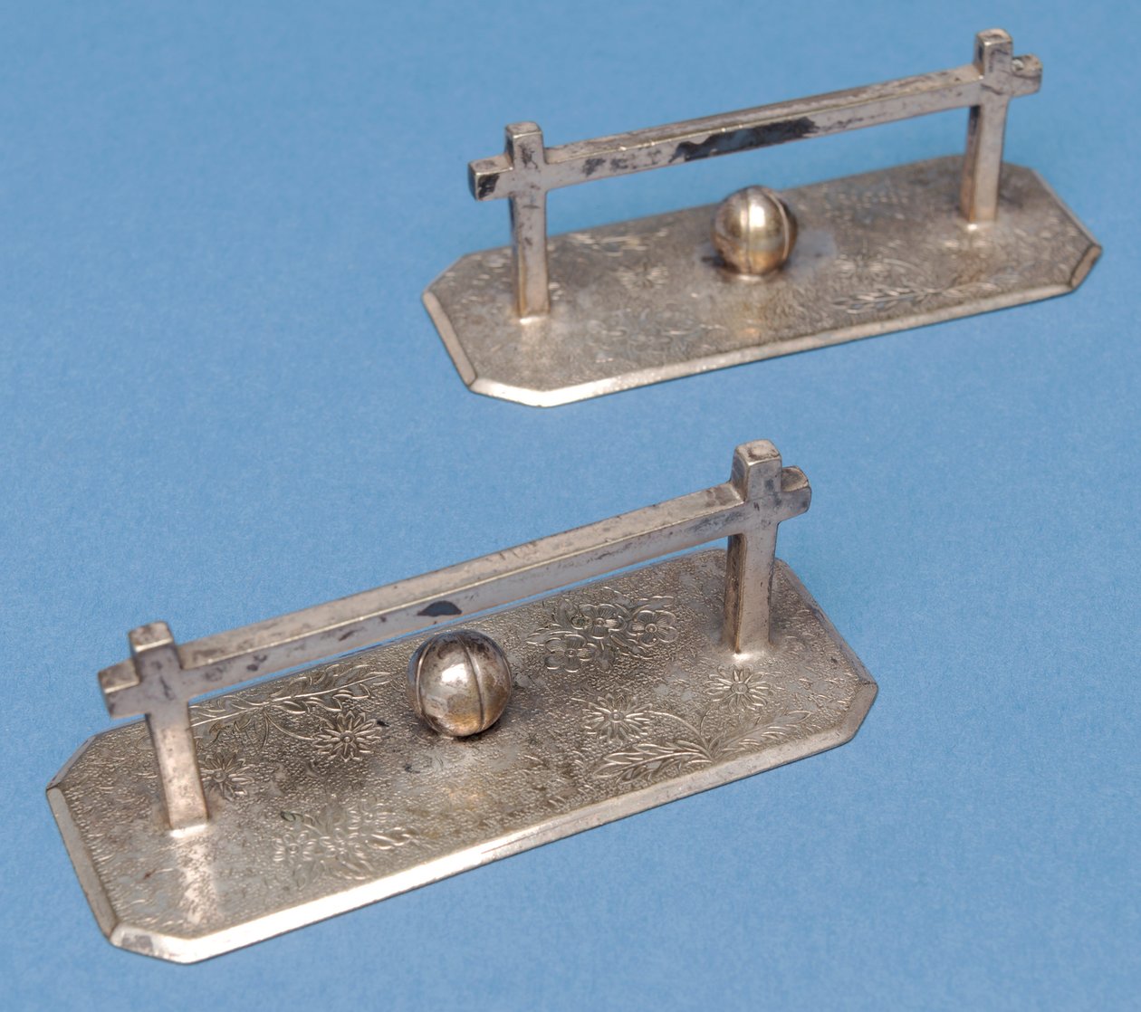 A faca de mesa descansa na forma de postes e bolas de futebol (metal branco) de English School