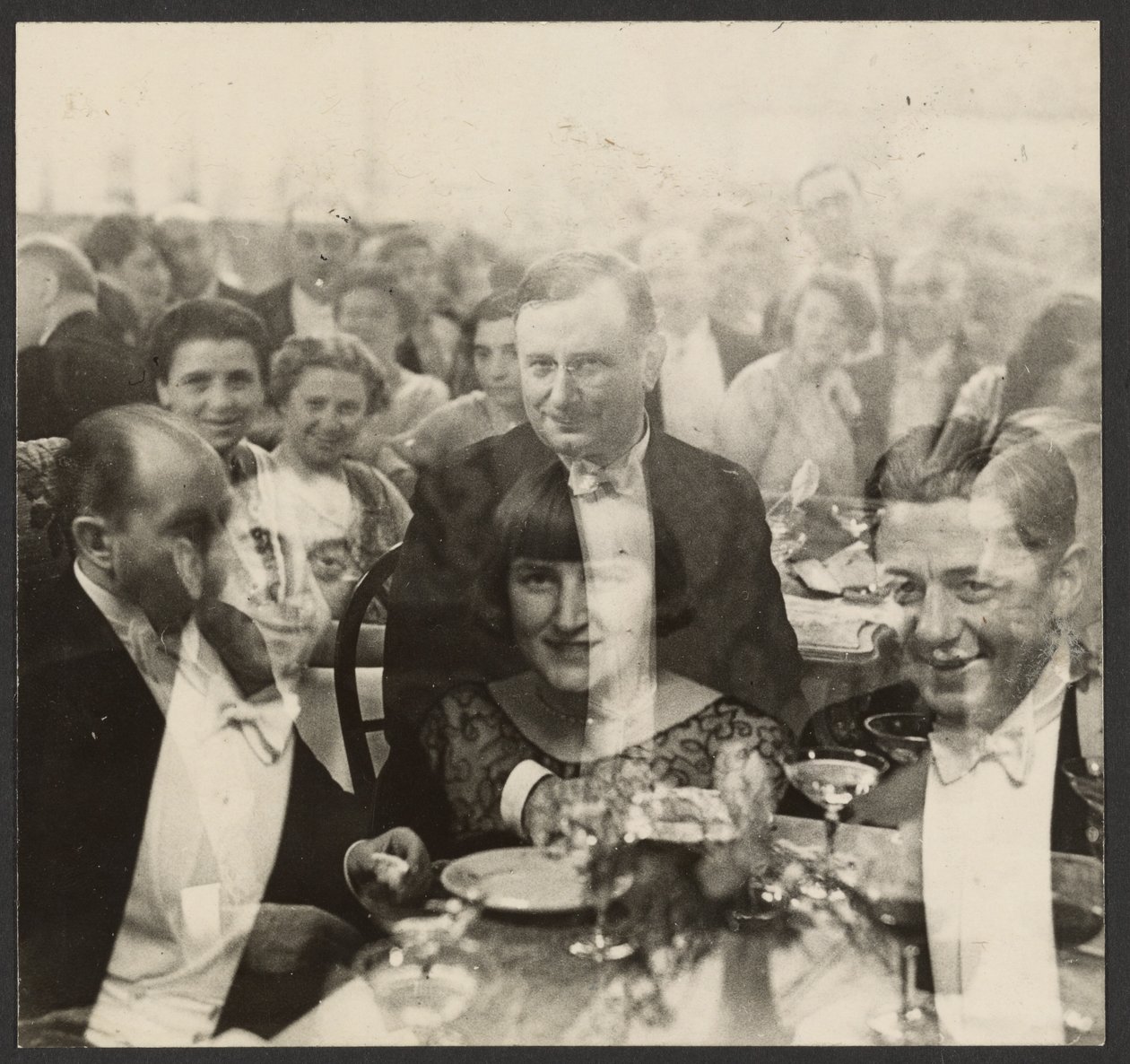 [Exposição dupla de um grupo de pessoas num banquete]. de Erich Salomon