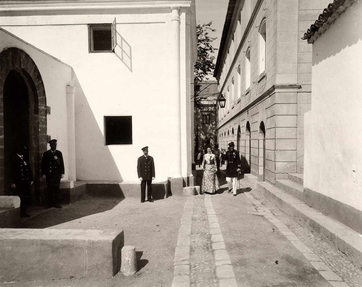 Homens de uniforme acompanhando uma mulher elegantemente vestida para a igreja da fazenda de Lo Zucco, Sicília, 1900 de Eugenio Interguglielmi