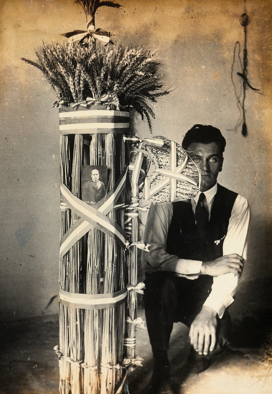 Antonio Floridi posando perto de fasces de lictores feitos de espigas de trigo. Fazenda de propriedade de Camillo Frizzoni, em Morengo, província de Bergamo. No topo do fasces é uma foto de Mussolini de F. Frizzoni
