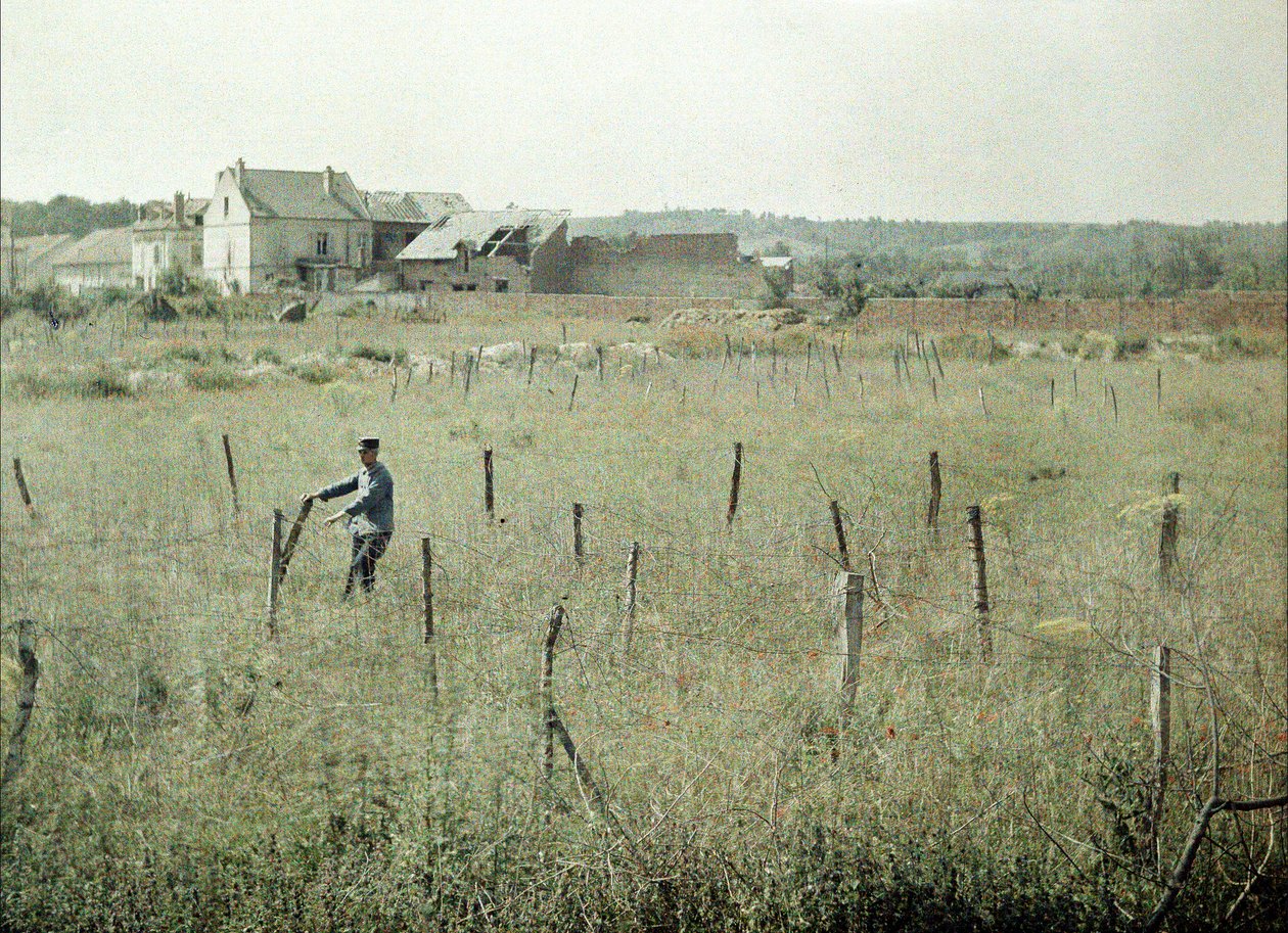 Um oficial francês inspeciona o arame farpado em torno das posições francesas, Soissons, Aisne, França, 1917 (autocrômico) de Fernand Cuville