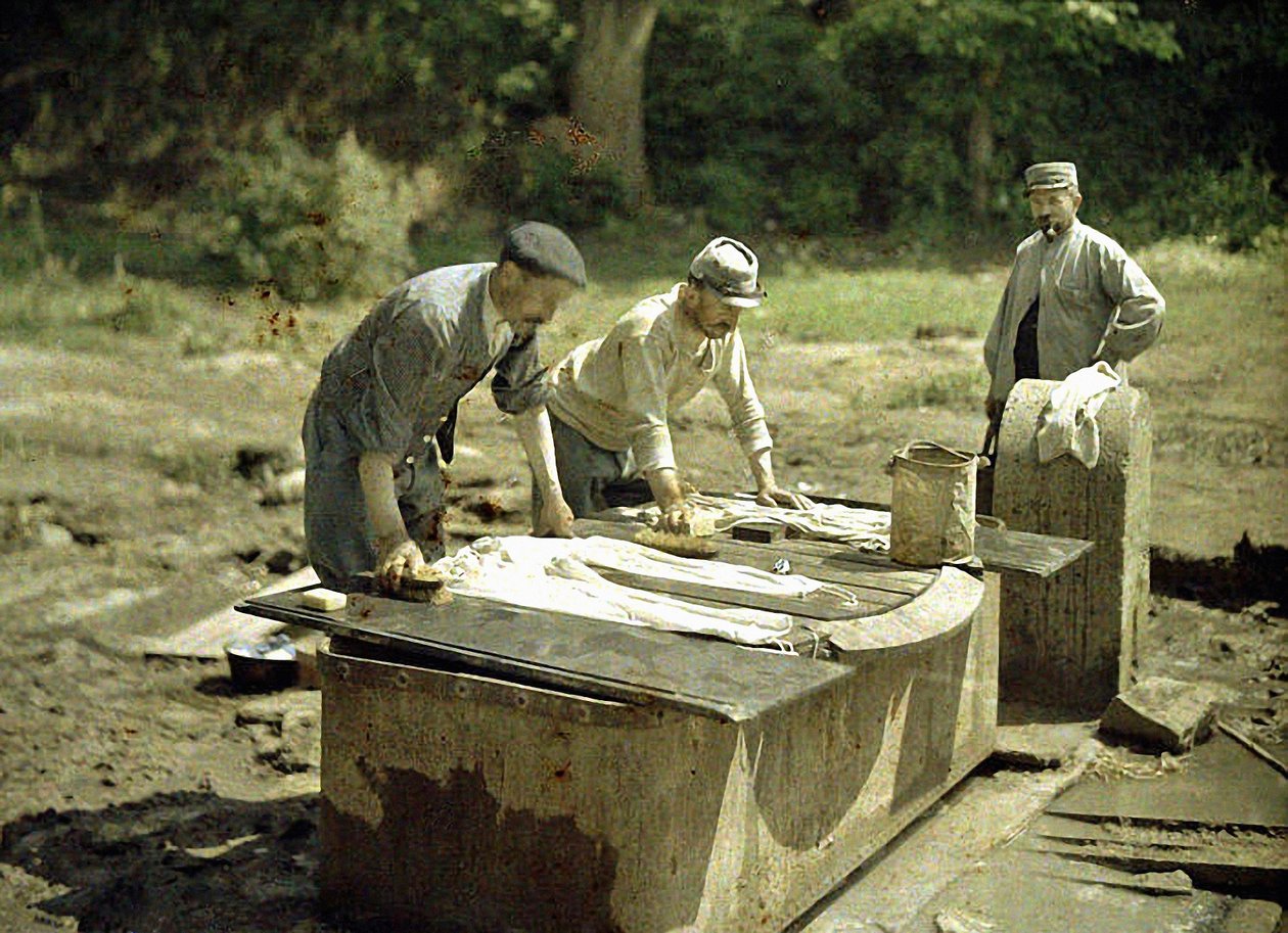 Três soldados franceses lavando roupa em um poço, Soissons, Aisne, França, 1917 (autocrômico) de Fernand Cuville