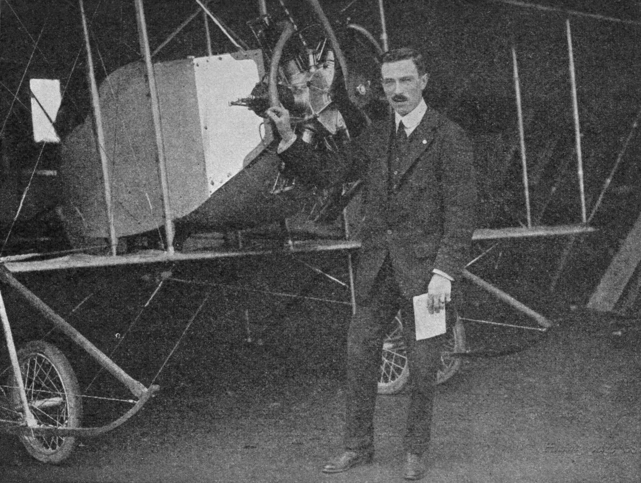 Um dos melhores instrutores: Lewis WF Turner em pé ao lado de um biplano de treinamento Caudron, 1913 1934 de Flight Photo