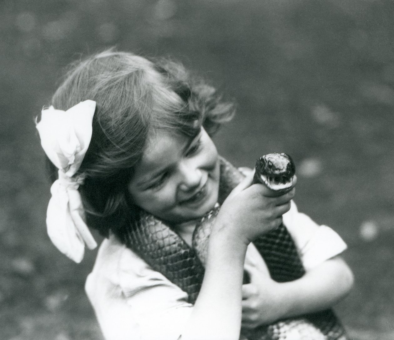 Uma jovem garota Betty segurando uma serpente de índigo Oriental, zoológico de Londres, 1924 de Frederick William Bond