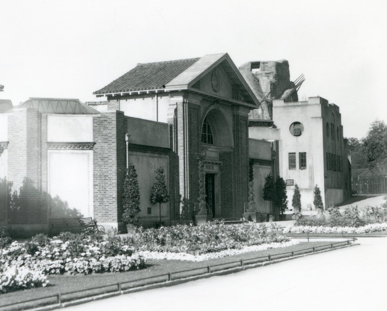A Casa do Réptil no Jardim Zoológico de Londres em 1928 com canteiros de flores formais ao longo dos caminhos para a entrada (foto a p/b) de Frederick William Bond