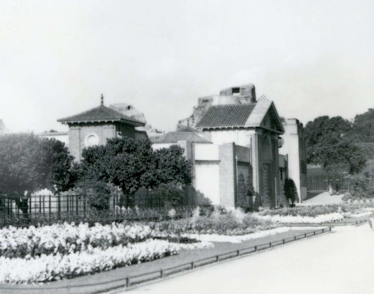 A Casa do Réptil no Jardim Zoológico de Londres em 1928 com canteiros de flores formais ao longo dos caminhos para a entrada, o Jardim Zoológico de Londres de Frederick William Bond