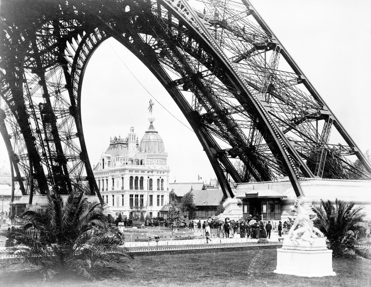 O pavilhão de gás visto através da base da Torre Eiffel, exposição de Paris, 1889 de French Photographer