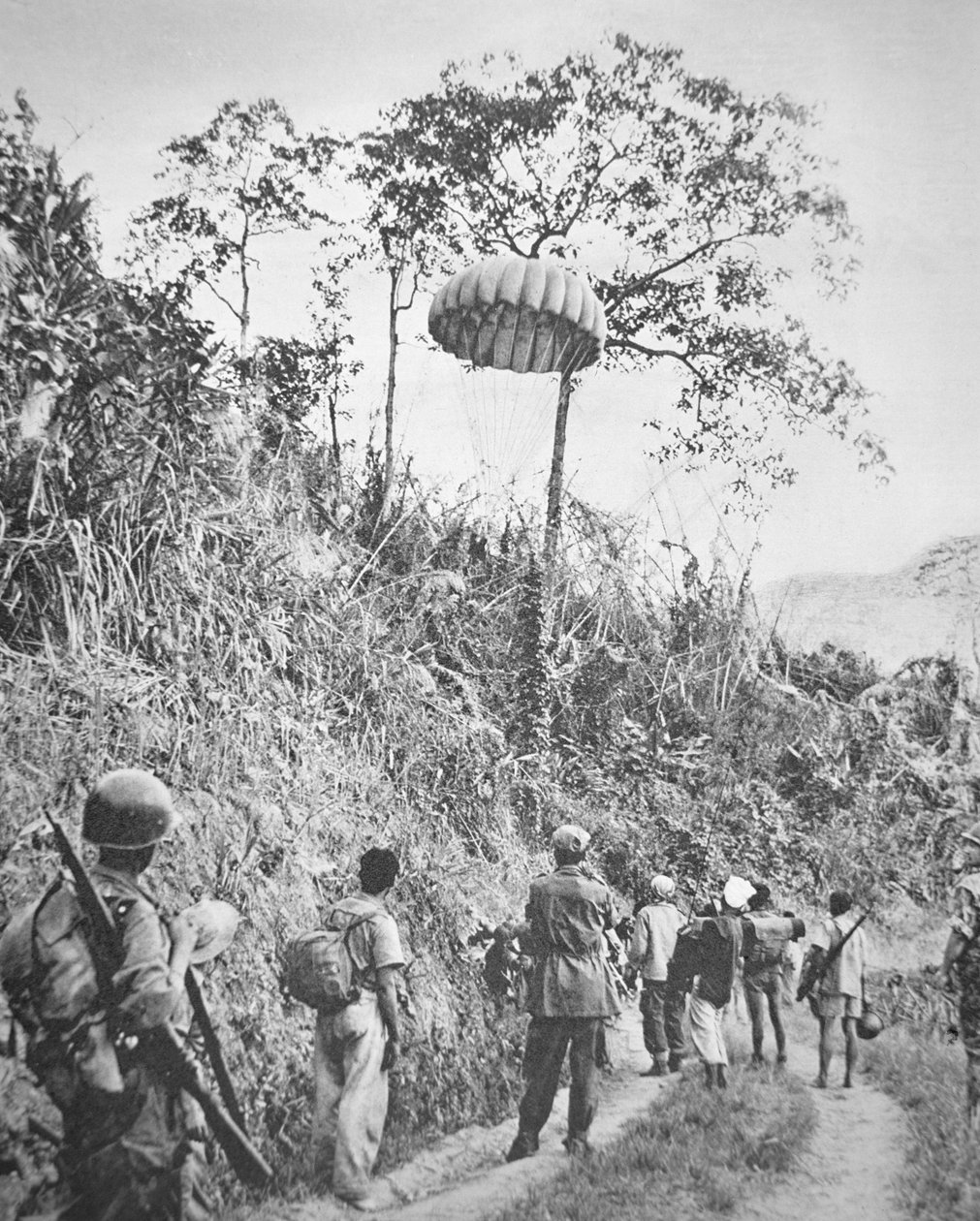 Soldados franceses e vietnamitas recuperam suprimentos de pára-quedas durante o cerco de Dien Bien Phu, entre novembro de 1953 e maio de 1954 (foto a p/b) de French Photographer