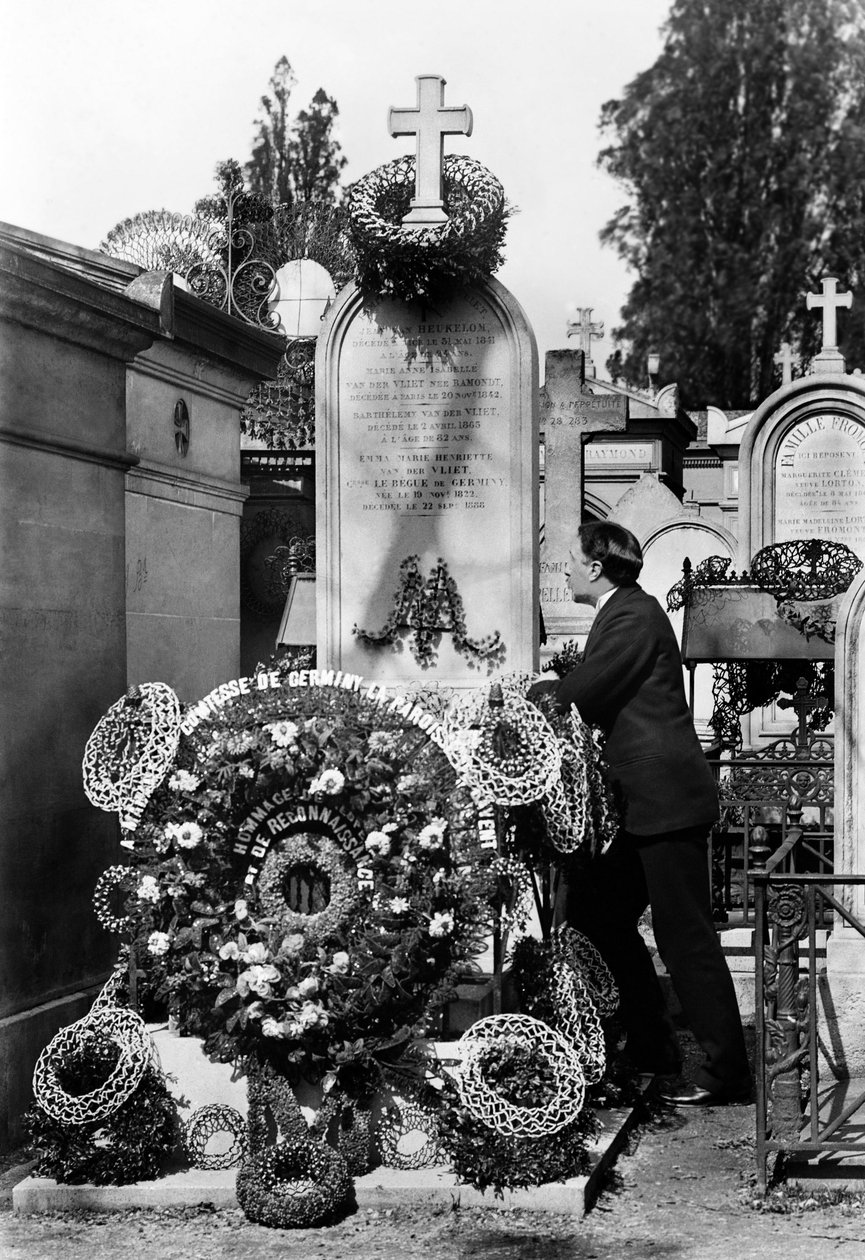 Coroas funerárias e homem recolhidos em frente ao túmulo de Emma Van Der Vliet, Condessa Le Begue De Germiny (1822-1888). Fotografia de finais do século XIX. Coleção Ducos. de French Photographer