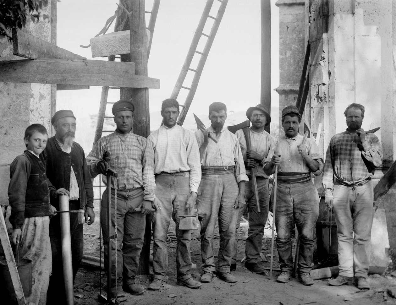 A equipe de carpinteiros, trabalhando na restauração da Abadia de Septfontaines, Bourmont en Haute-Marne (Haute Marne), posando com suas ferramentas, machado, serra, fio de chumbo, regras e massa, por volta de 1890. Fotografia. Coleção Ducos. de French Photographer