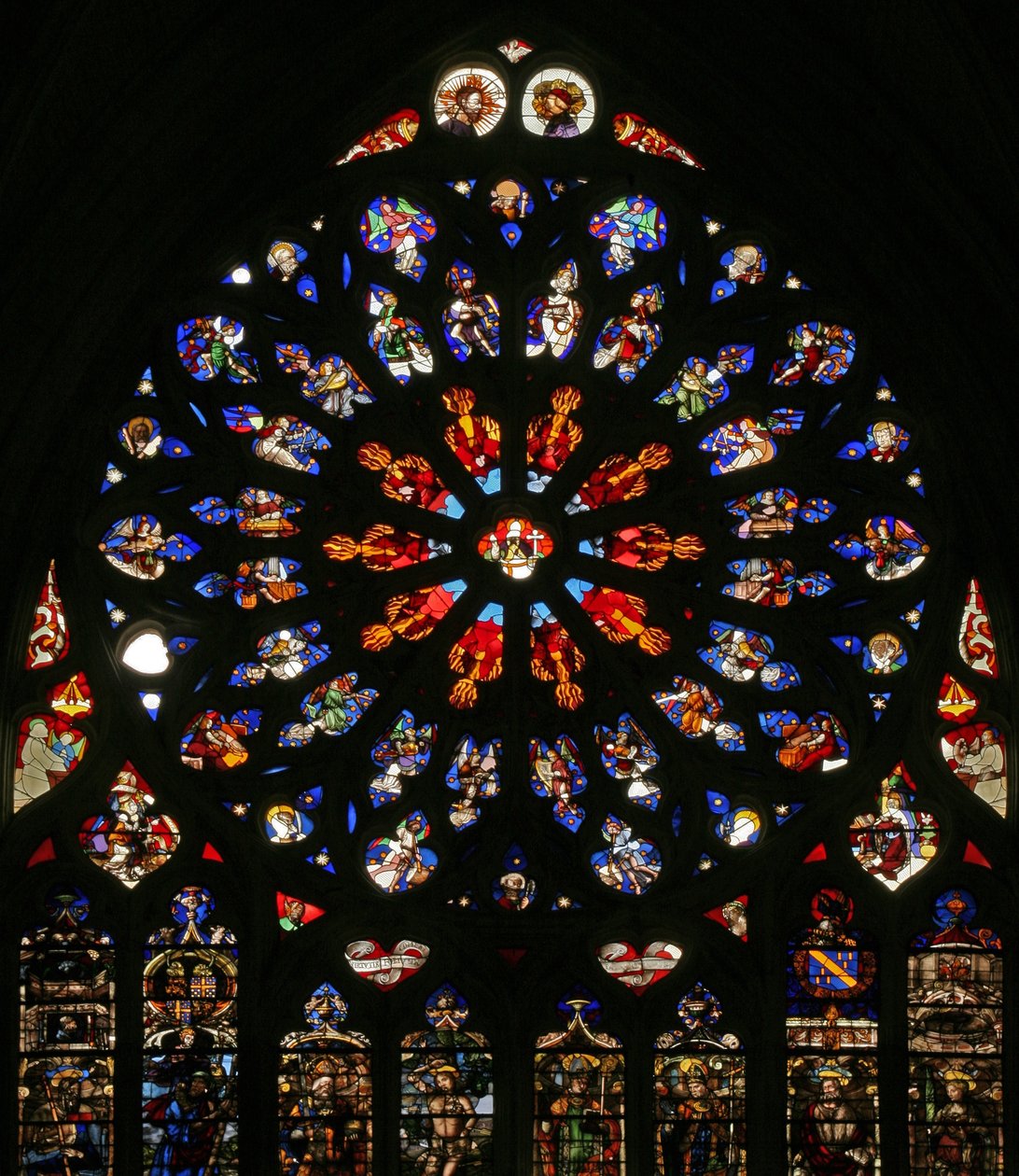 Janela retratando Deus, serafins, anjos musicais e dez dos apóstolos. as lancetas abaixo contêm figuras tardias do C16, os santos padroeiros dos então cânones: - St James, St Christopher, St Charlemagn de French School