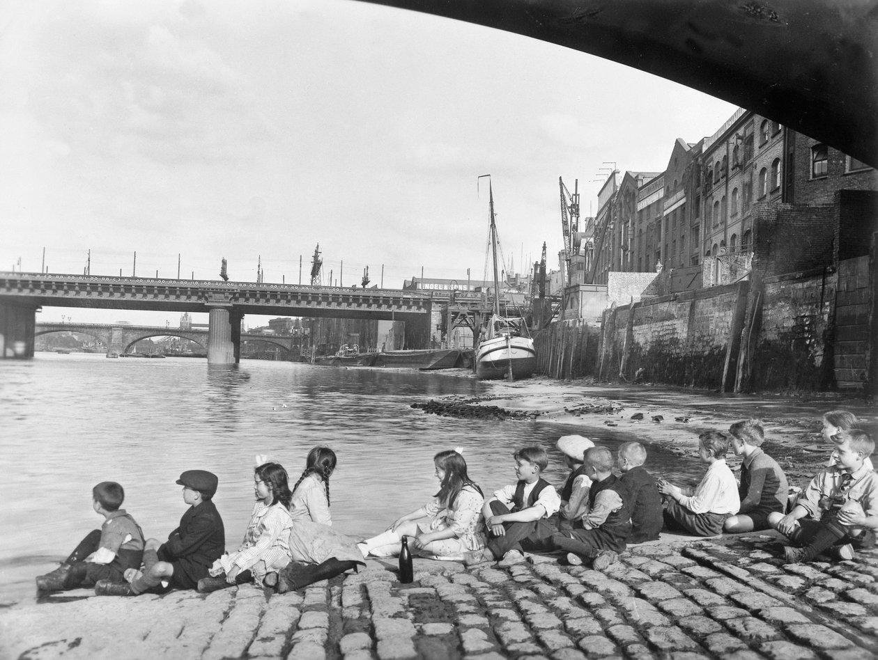 Crianças na calçada de paralelepípedos sob Southwark Bridge, Londres, c1930 de George Davison Reid