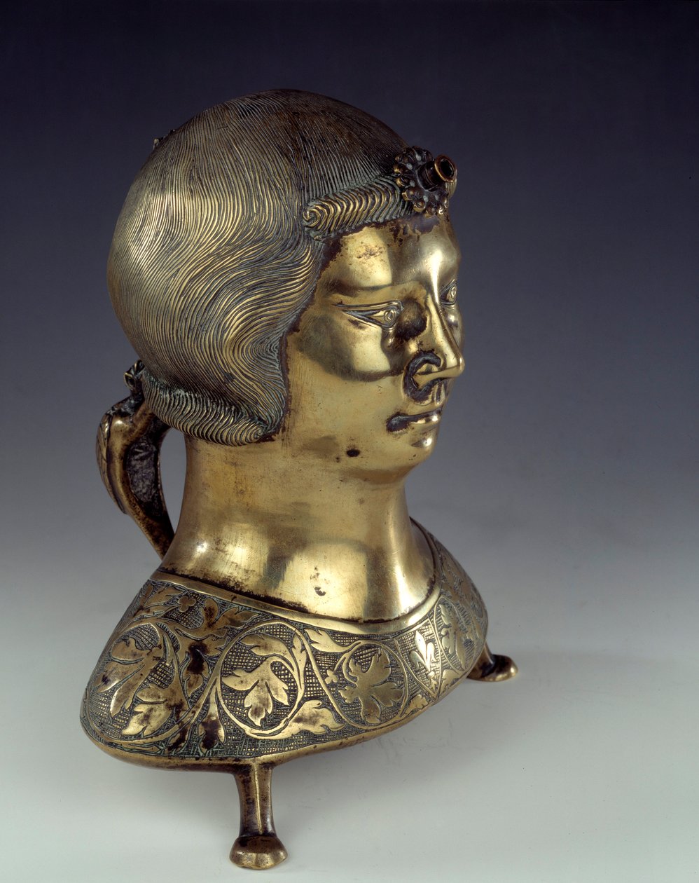Aquamanile (bacia para lavar as mãos do padre durante a missa) em bronze dourado na forma do busto de um jovem. 1300-1325. De Hildesheim. Sol 0,23x0,19 m Paris, museu nacional da Idade Média, Termas de Cluny. de German School