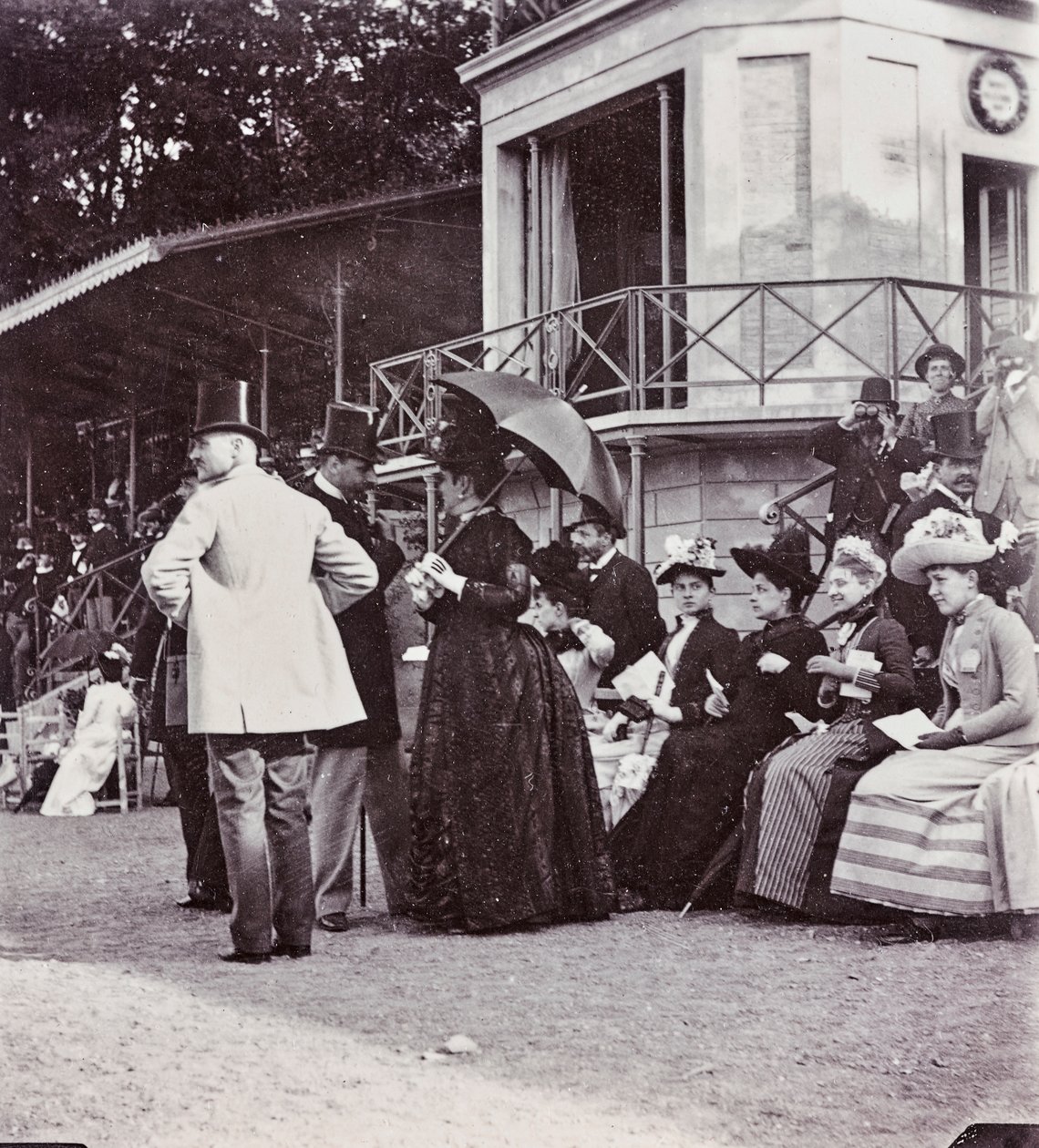 Os espectadores nas bancadas controlam o resultado de uma corrida no hipódromo do Parque Cascine: J. Halphon, Miss Serjeaf, duquesa de Brindisi, duquesa de Rohorn, condessa Della Gherardesca, marquês Bellisomi, Gondi de Giorgio Enrico (attr.to) Levi