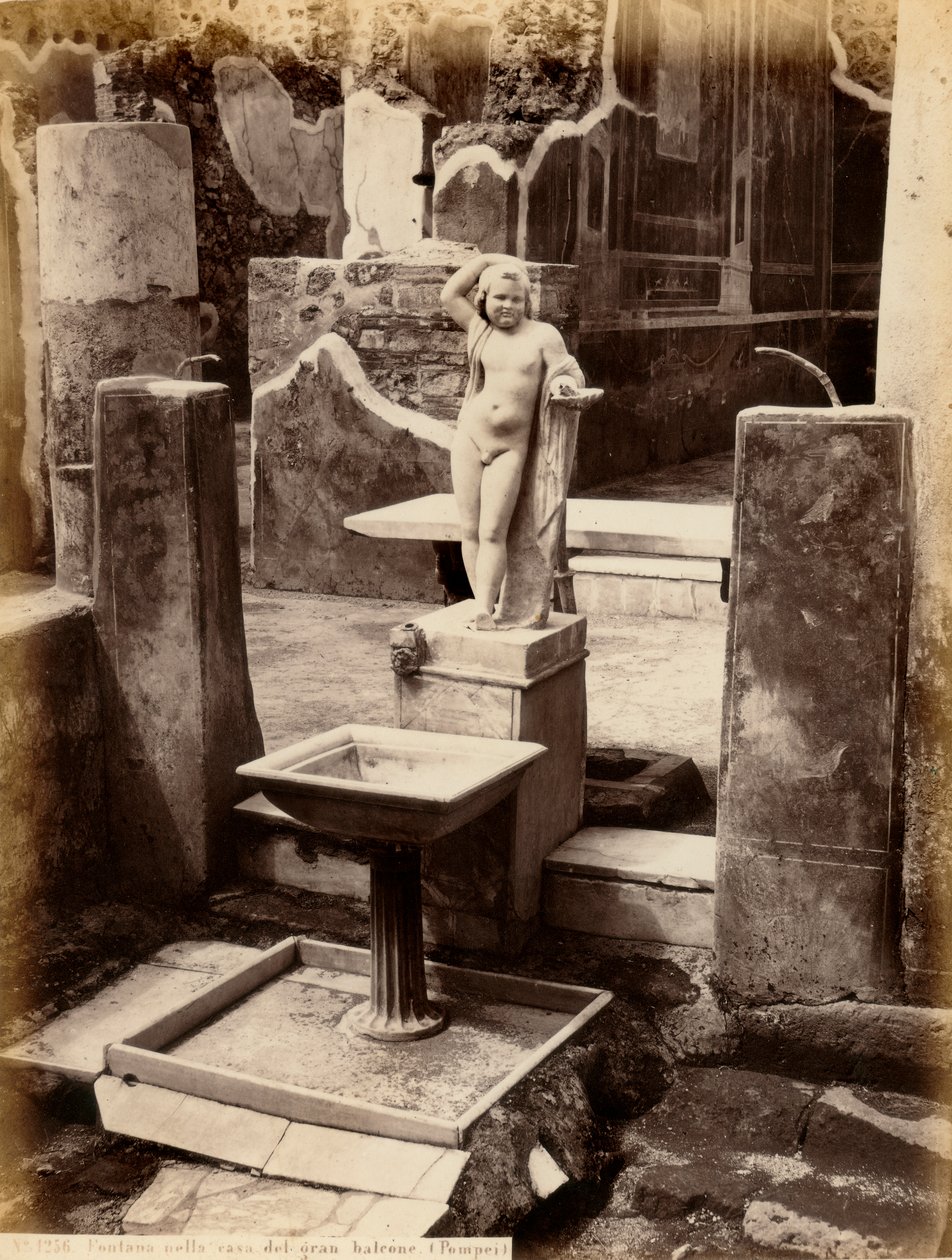 Uma fonte composta por uma escultura de um rapazinho nu. A fonte está na Casa de Balcone pensile, em Pompei. de Giorgio Sommer