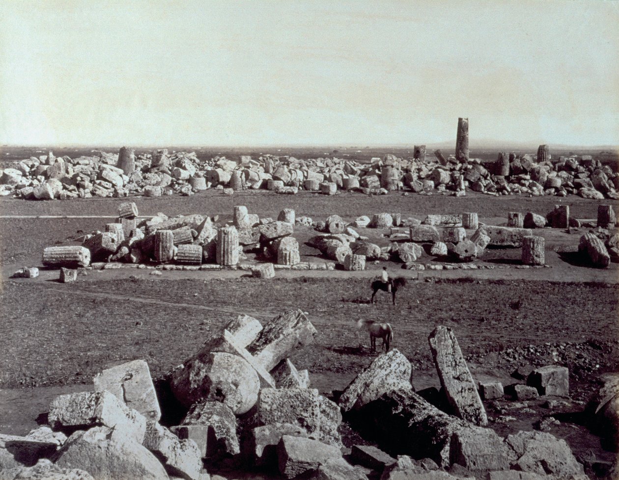 Panorama dos restos mortais do Templo de Minerva e do Templo de Apolo em Selinunte. Há um homem a cavalo entre as ruínas do sítio arqueológico. de Giorgio Sommer