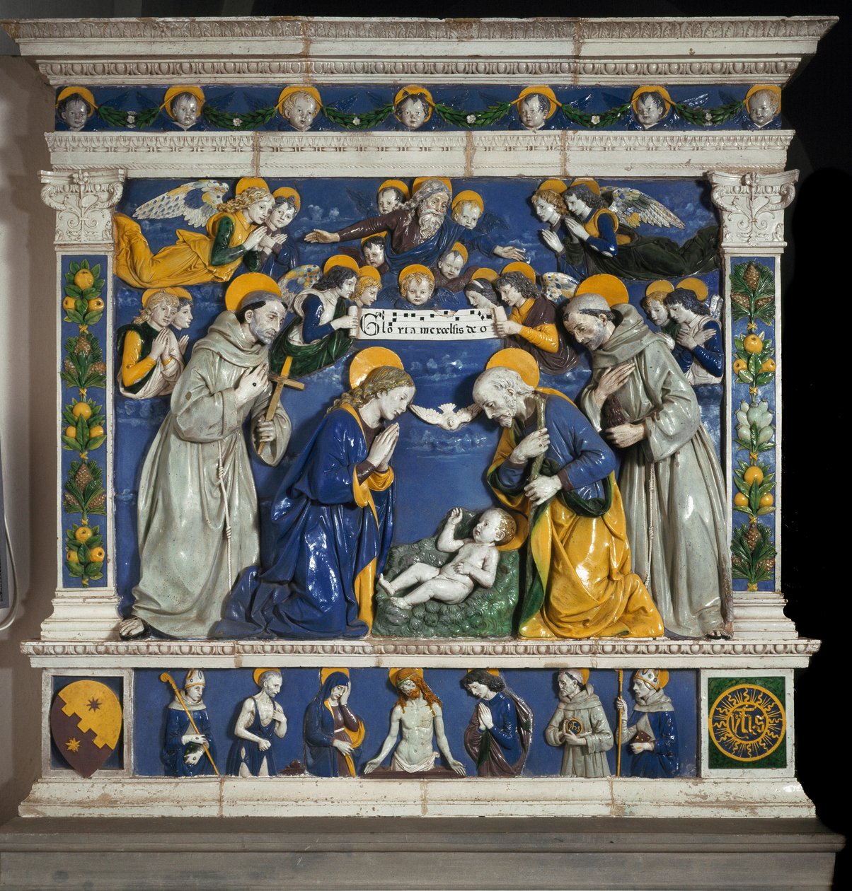 A Natividade com São Francisco de Assis e Santo Antônio de Pádua (san antonio di padova) Representação da Santíssima Trindade com Deus, Jesus Cristo e a pomba do Espírito Santo. Cerâmica em alto relevo de Giovanni della Robbia (1469-1529) cerca de 1485 Dim de Giovanni della Robbia