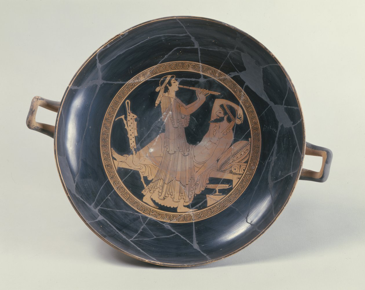 Copa ática de figuras vermelhas representando uma mulher tocando uma flauta dupla (cerâmica) de Greek