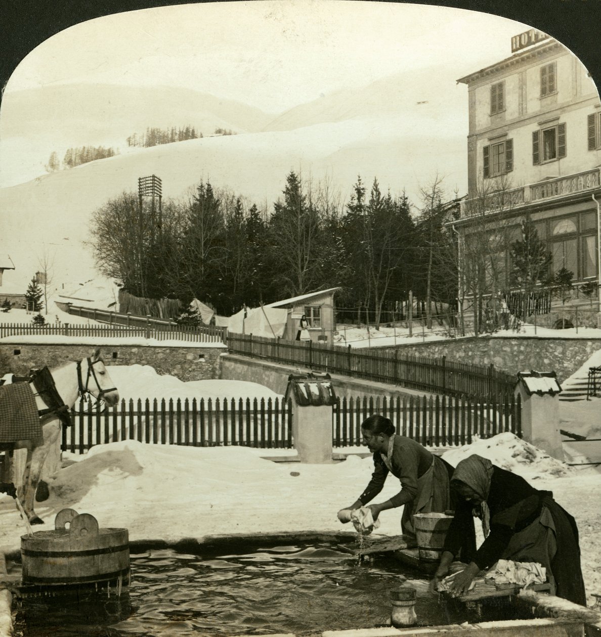 Mulheres lavando roupas na fonte pública no meio do inverno, Zuoz, Suíça de H. C. White