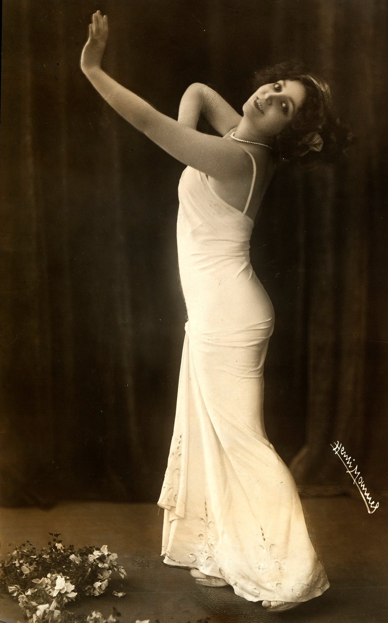 Retrato da atriz francesa Regina Badet numa pose evocativa, com um vestido branco comprido. de Henri Manuel