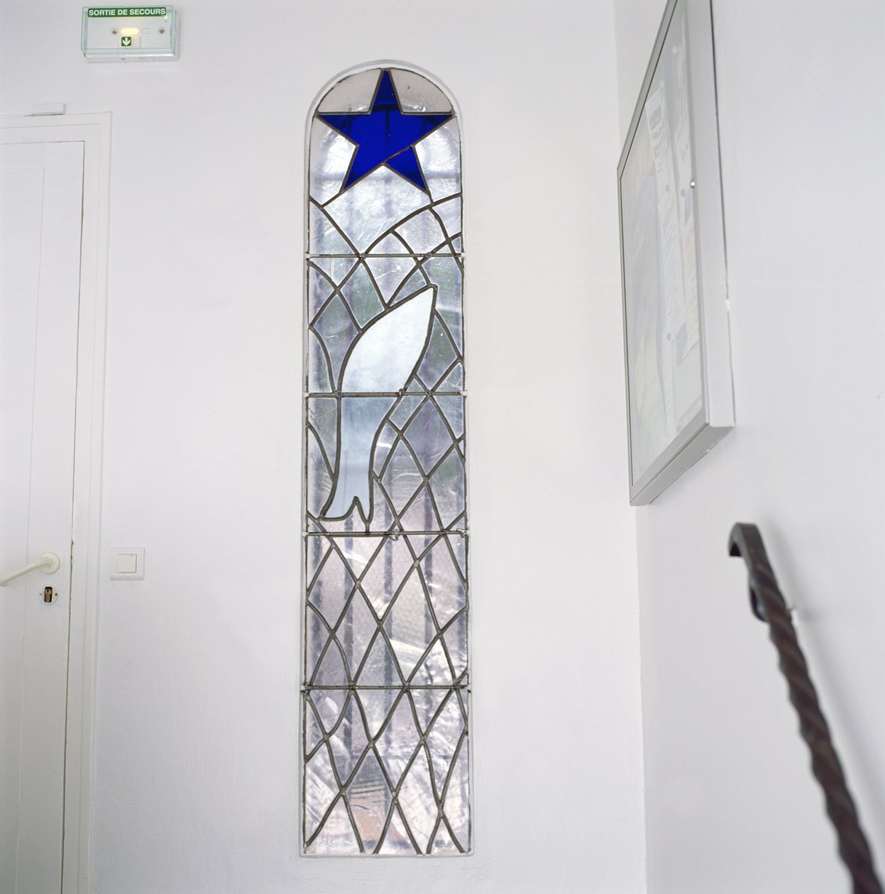 Vitral representando um peixe apanhado numa rede sob a Estrela da Salvação, a partir das escadas que conduzem à Capela do Rosário de Henri Matisse