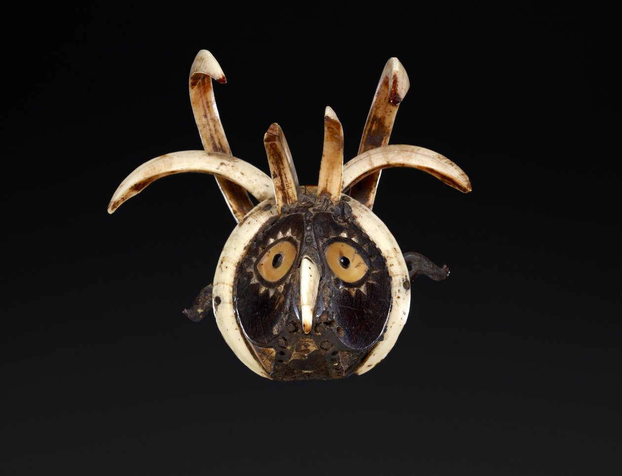Máscara bucal provavelmente representando a cabeça de um galo (madeira, presas de javali, concha, madrepérola, chifre de búfalo, material resinoso e pigmento) de Indonesian School