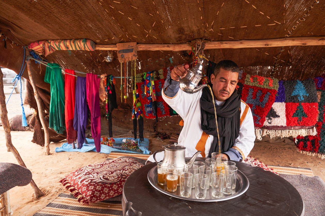 Um habitante local serve chá de menta no Erg Chebbi, no deserto perto de Merzouga, Marrocos, 2019 (foto) de Ira Block
