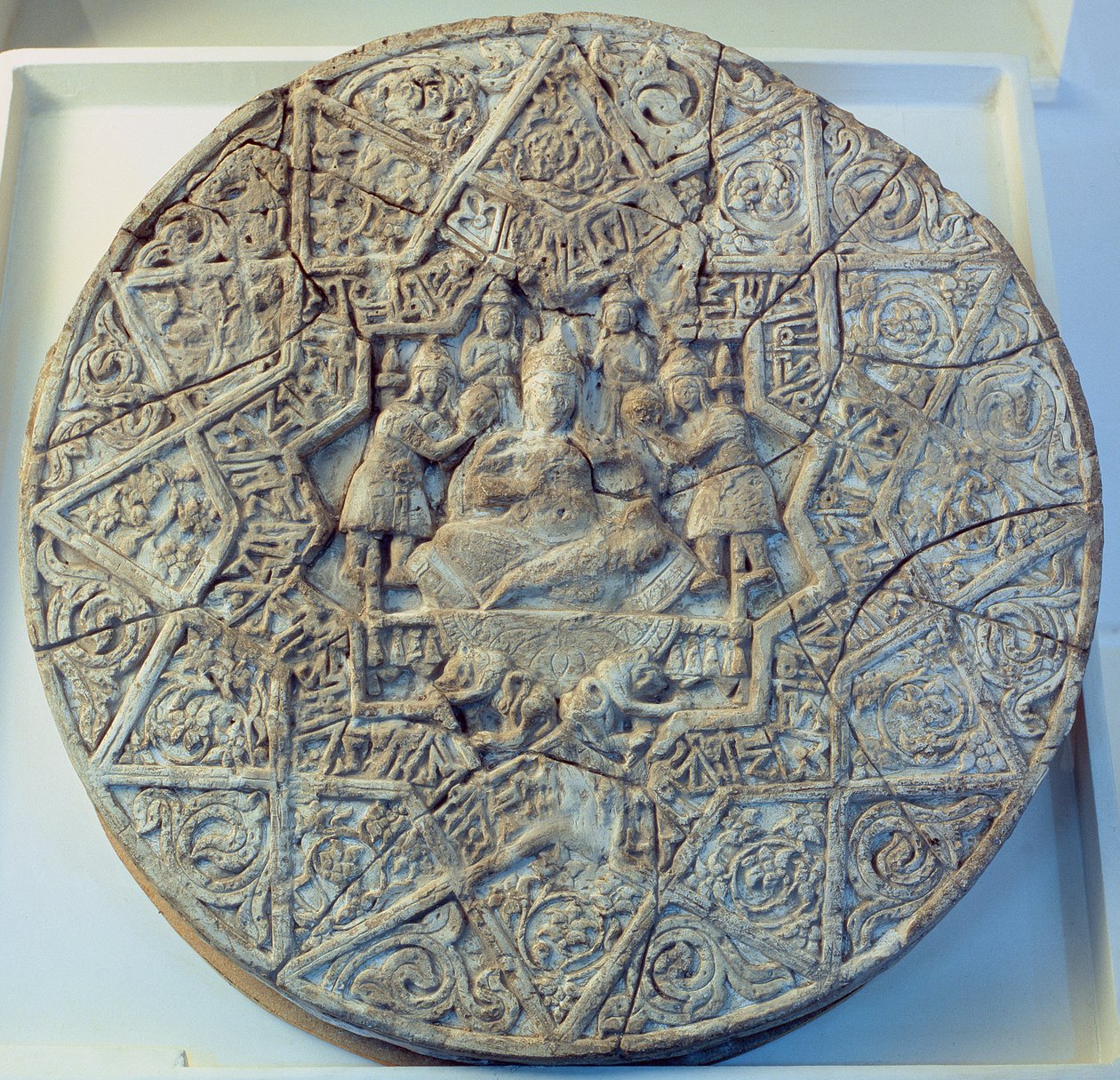 Disco solar retratando um rei sentado de pernas cruzadas em um trono ladeado por dois anjos no centro, encontrado em Ray, Irã (estuque) de Islamic School