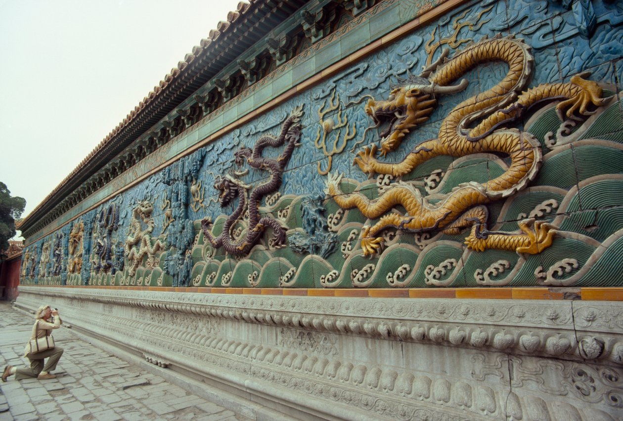 Uma mulher fotografa o ecrã dos nove dragões. Parque Beihai, Pequim, República Popular da China. de James L Stanfield