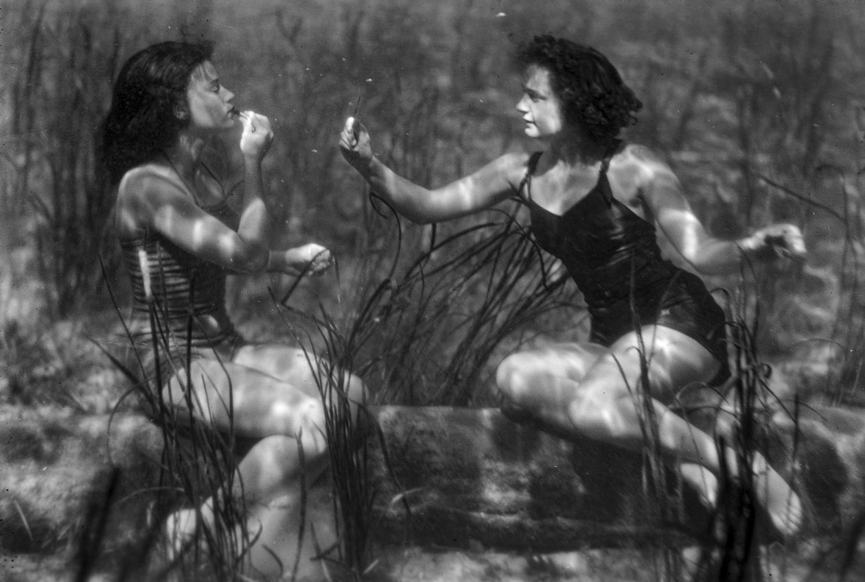Mulheres debaixo de água a aplicar batom numa atração turística, Florida de Jay Baylor Roberts
