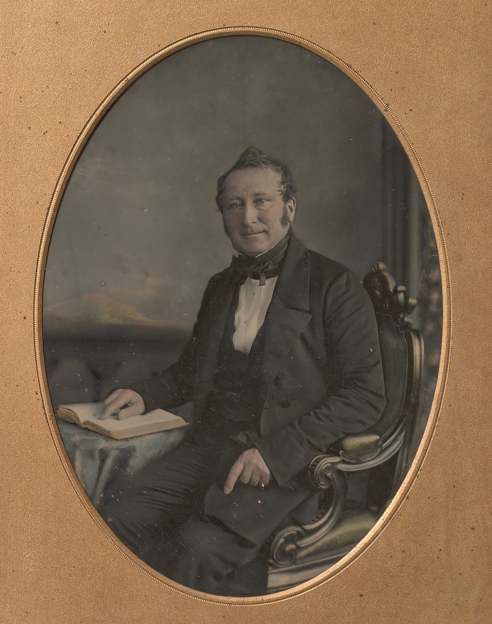 Homem sentado apontando para uma passagem em um livro aberto, década de 1850. de John Jabez Edwin Mayall