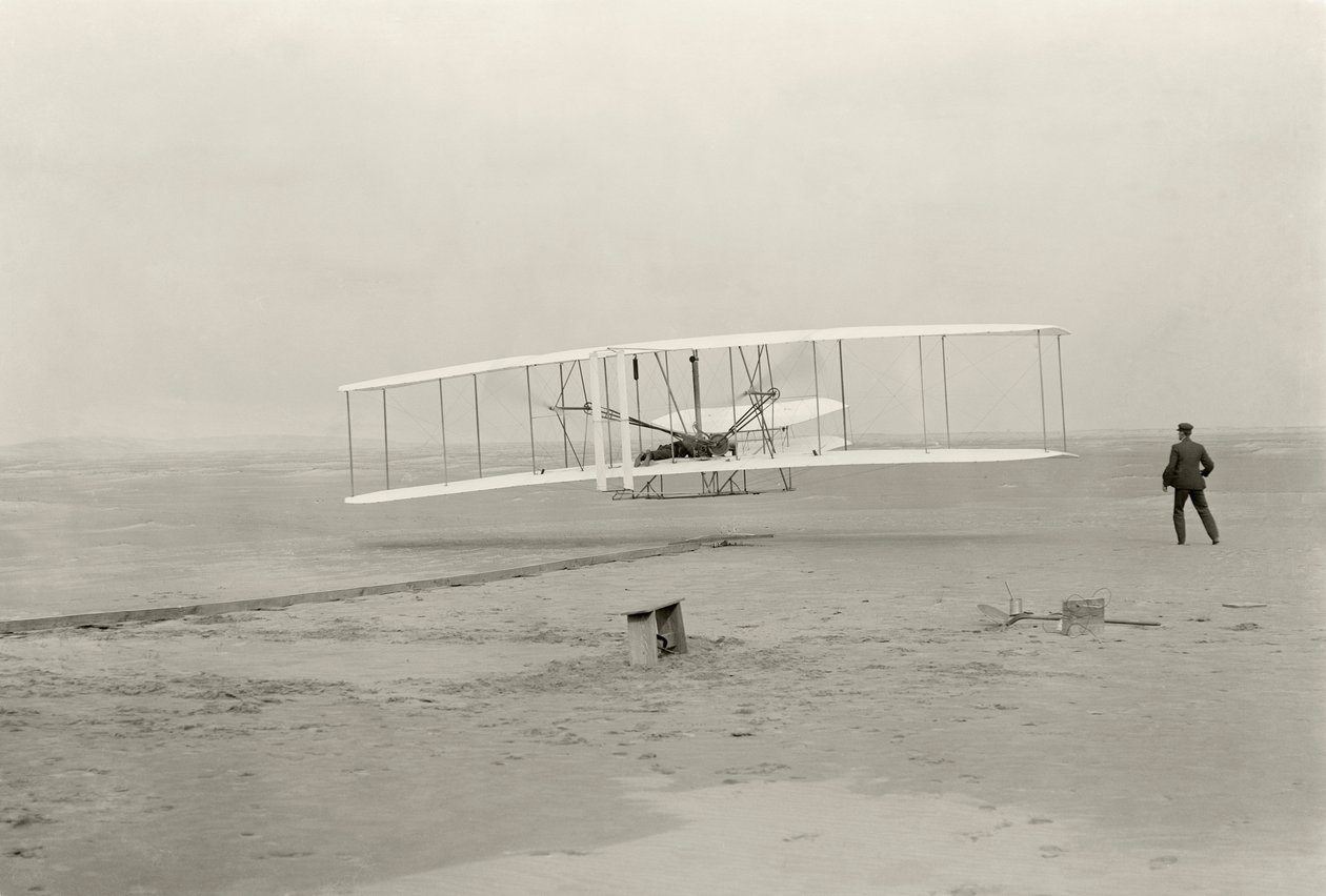 O Wright Flyer I faz o seu primeiro voo de 120 pés em 12 segundos, em Kitty Hawk, Carolina do Norte de John T. Daniels