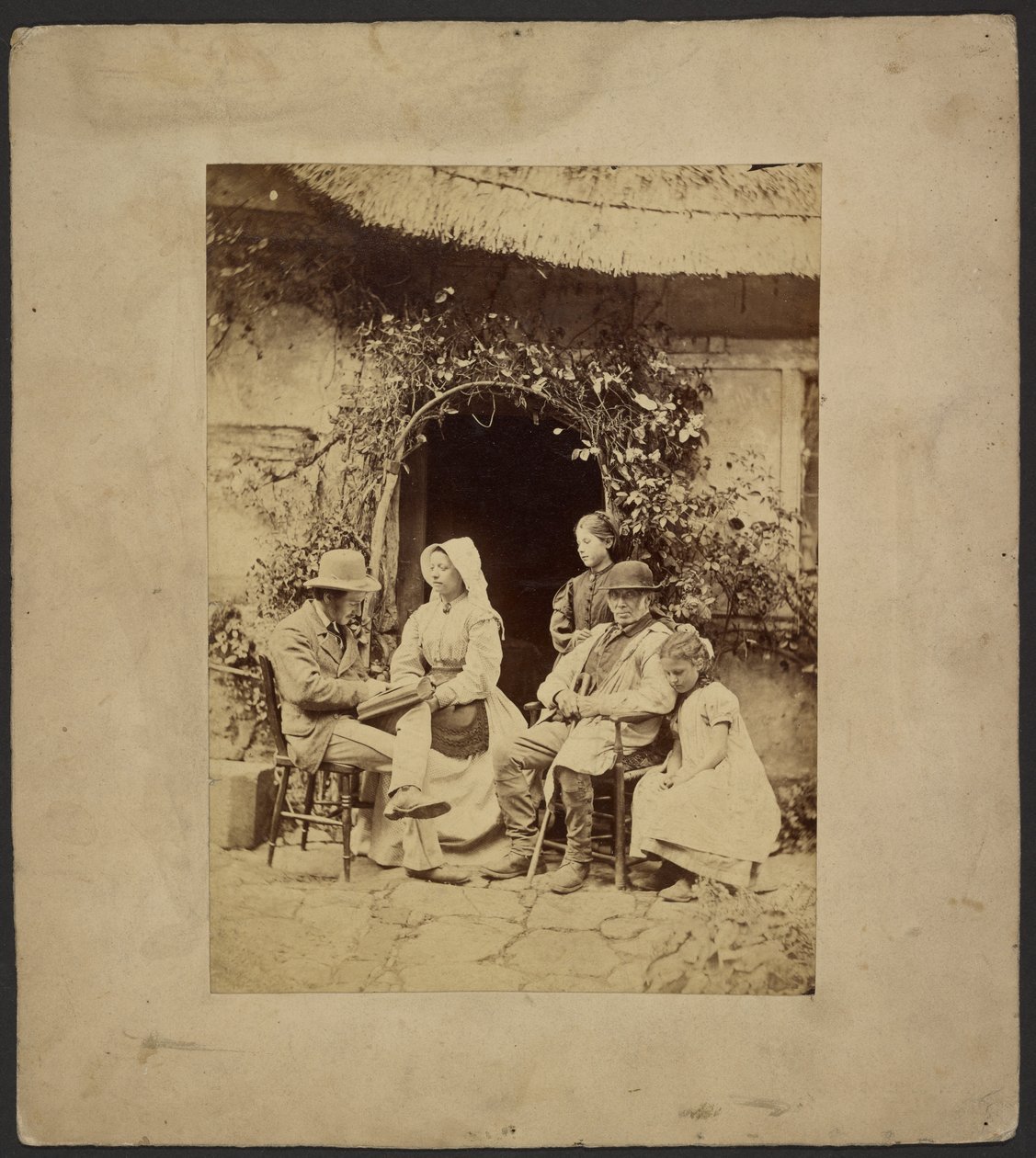 [Grupo sentado à porta aberta: dois homens de chapéu, uma mulher de chapéu, duas raparigas - uma de pé]. de John Whistler