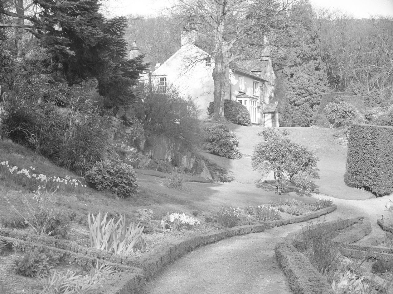 Um edifício pálido rodeado por jardins paisagísticos de Joseph Hardman