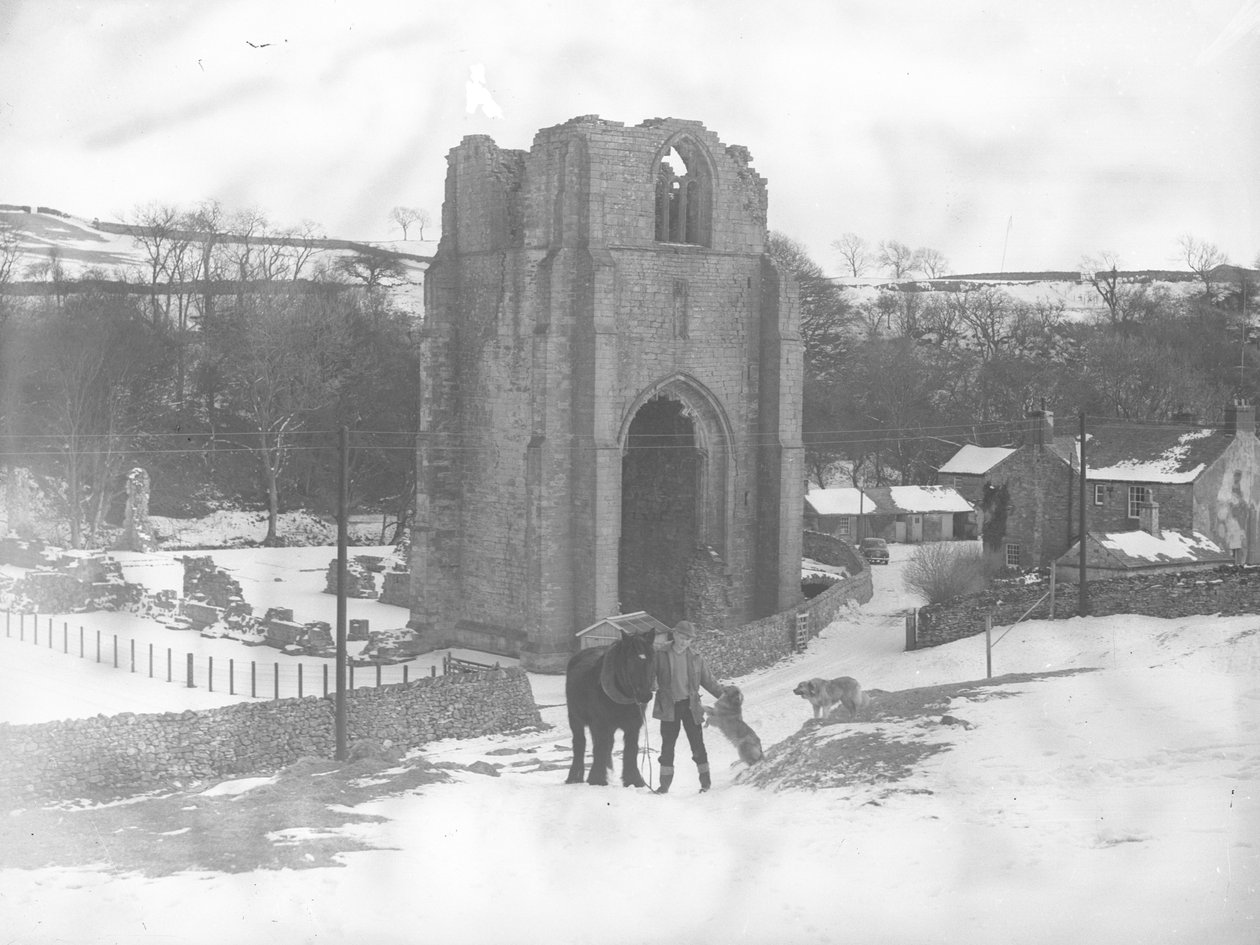 Homem com cavalo e dois cães em frente à Abadia de Shap permanece na neve de Joseph Hardman