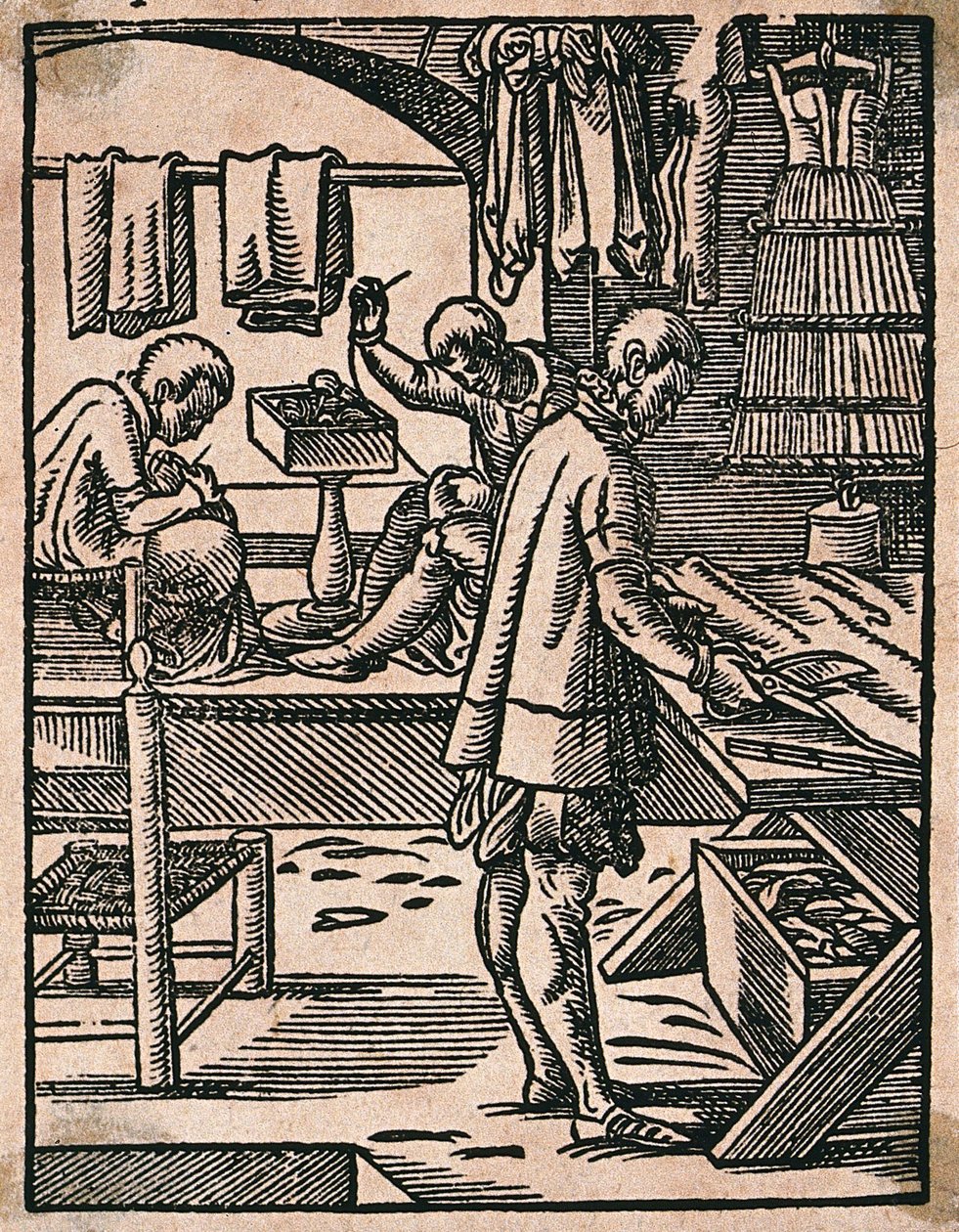 Um alfaiate corta tecido com tesouras enquanto os seus colegas cosem a uma bancada. Xilogravura de J. Amman. de Jost Amman