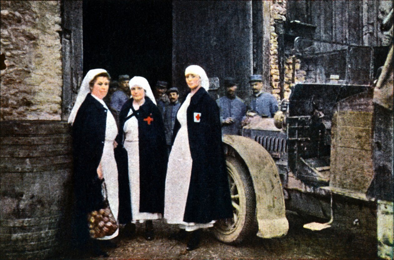 Três mulheres vestindo a Cruz Vermelha e a equipe de ambulância francesa com um veículo, Verdun, setembro de 1916 (autocrômico) de Jules Gervais Courtellemont