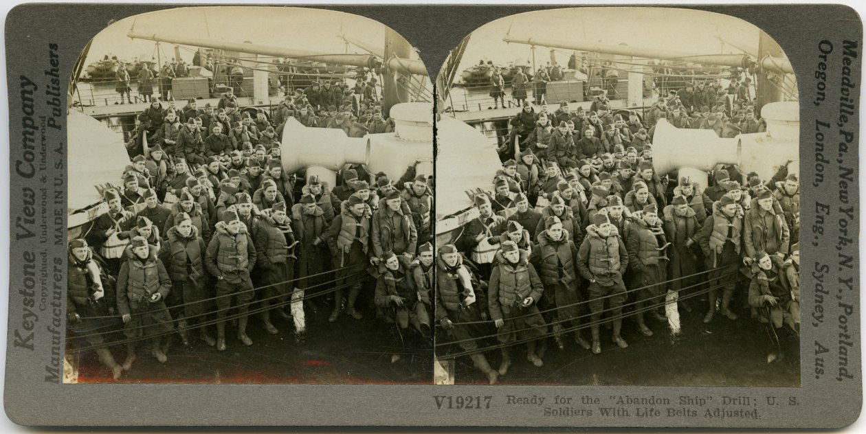 Estereocardia horizontal, do sepia que mostra soldados americanos uniformizados que vestem as coletes salva-vidas que estão e que sentam-se na plataforma de um navio. Número de estereógrafo Keystone V19217. O título lê de Keystone View Company