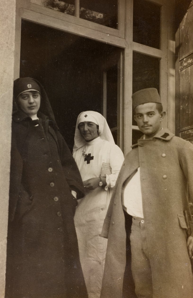 Álbum da Primeira Guerra Mundial em Friuli-Venezia Giulia: Retrato de duas enfermeiras da Cruz Vermelha com um cadete prisioneiro austríaco na Villa Brazzà, casa de 17 do Hospital de guerra em Soleschiano Manzano (foto a p/b) de L. Verdiani