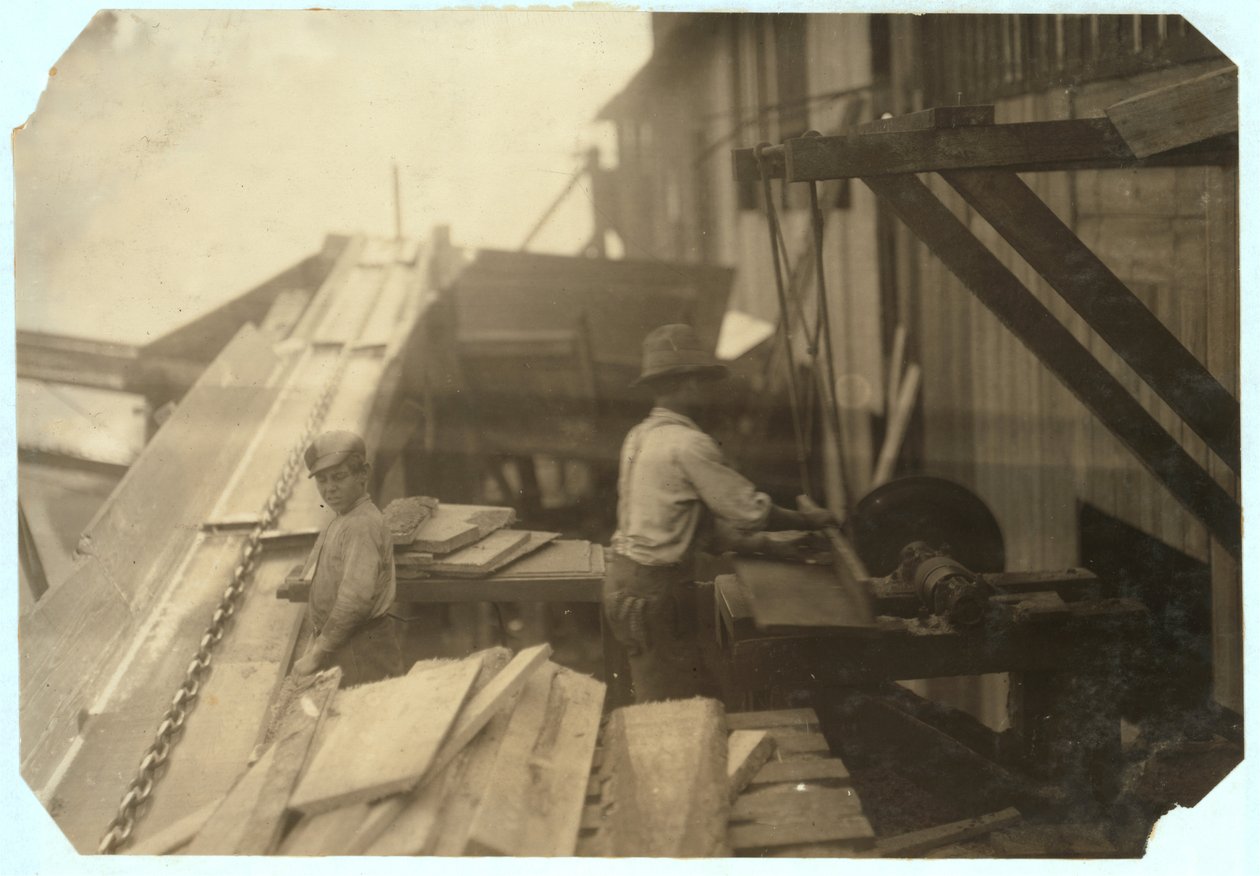 Charlie McBride, de 12 anos, tira madeira de uma calha durante 10 horas na Miller und Vidor Lumber Company, em Beaumont, Texas, pelo qual ganha 50 centavos, enquanto o outro o via em uma serra circular desprotegida, 191 de Lewis Wickes Hine