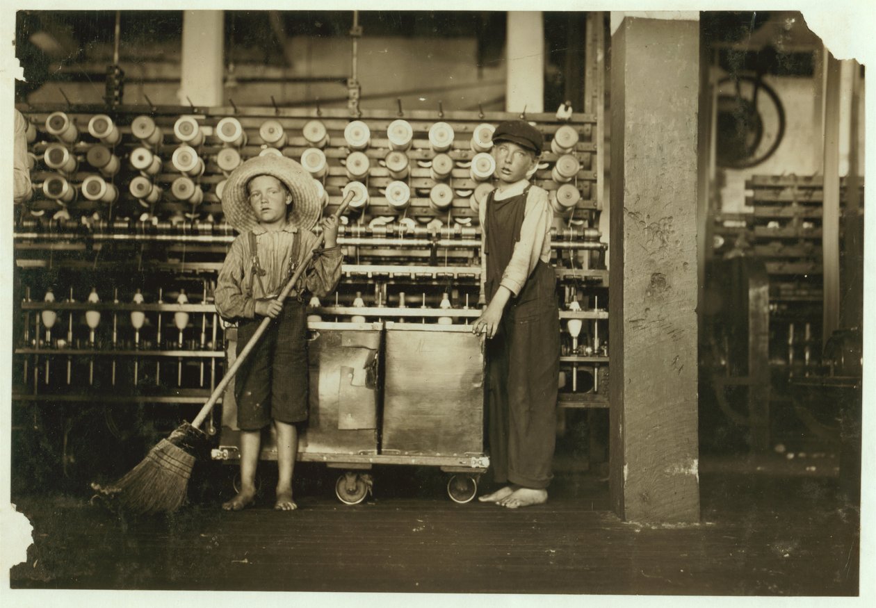 Ronald Webb, dono de 12 anos, e Frank Robinson, de 7 anos, filho de chefe de sala de jogos, que varre e despoja (limpa as bobinas cheias) em Roanoke Cotton Mills, Virgínia, 1911 de Lewis Wickes Hine