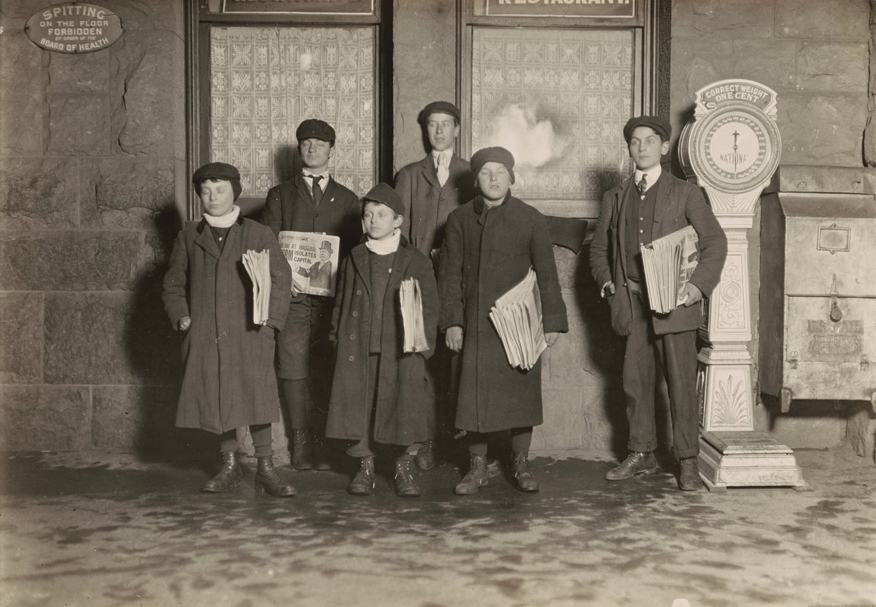 8:30 P.M. Grupo de jornaleiros a vender no depósito, Hartford, Connecticut. O rapaz mais pequeno tem 11 anos de idade, março de 1909 (foto) de Lewis Wickes Hine